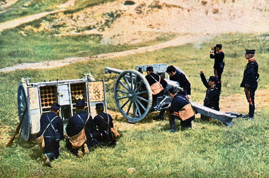des soldats s'affairent autour d'un canon de 75 utilisé lors de la première
